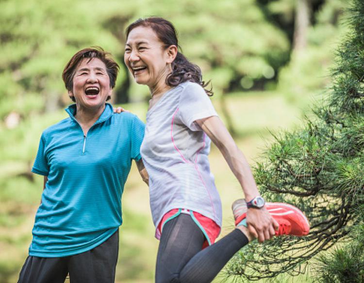 Mother and daughter stretching outside and enjoying themselves.